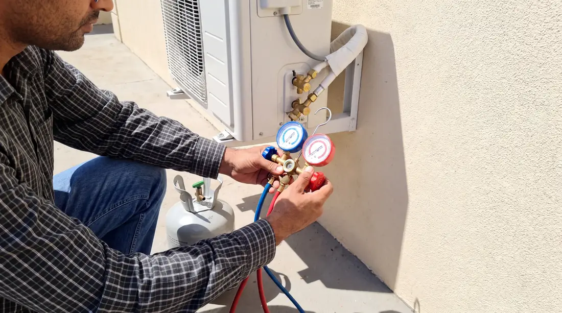Técnico conectando manifold à condensadora para carga de gás