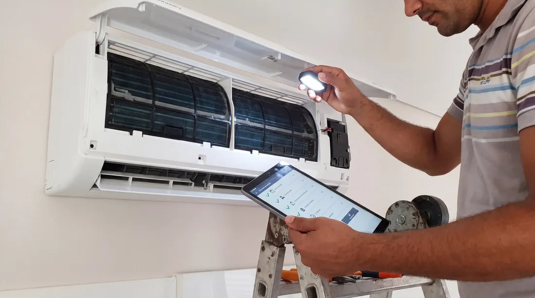 Técnico inspecionando a evaporadora aberta com lanterna